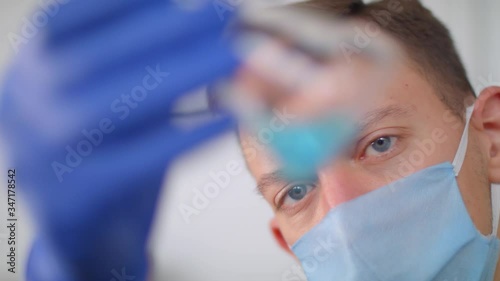 Medical worker explore the flask with the drug. Pills for viruses and diseases.
