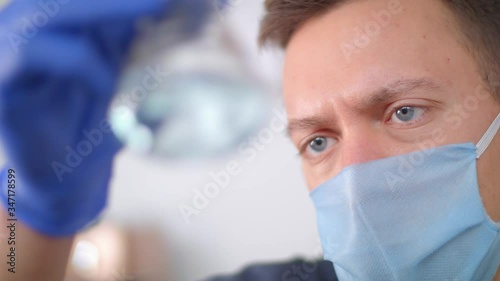 The doctor looks at the medicine in an ampoule. Health worker during a pandemic.