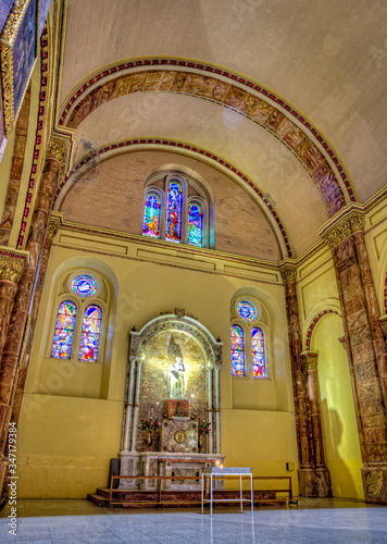 Cuenca, Ecuador, November 2013: Interior of the city's cathedral with it's stained glass windows, arches, marble columns and floors, and colonial decorations. © alanfalcony