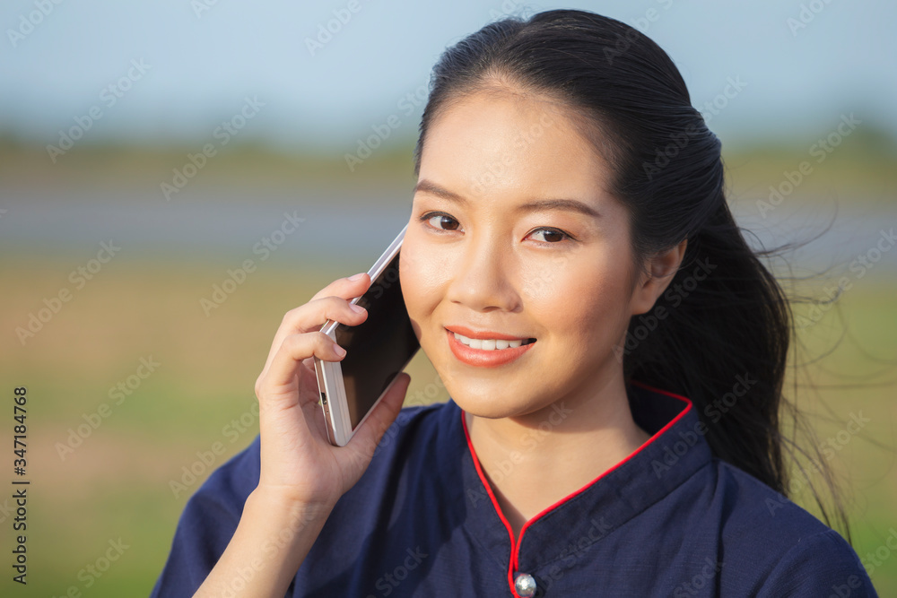 Happy young Asian woman smiling while using smartphone. Happy young Asian woman smiling while using smartphone.