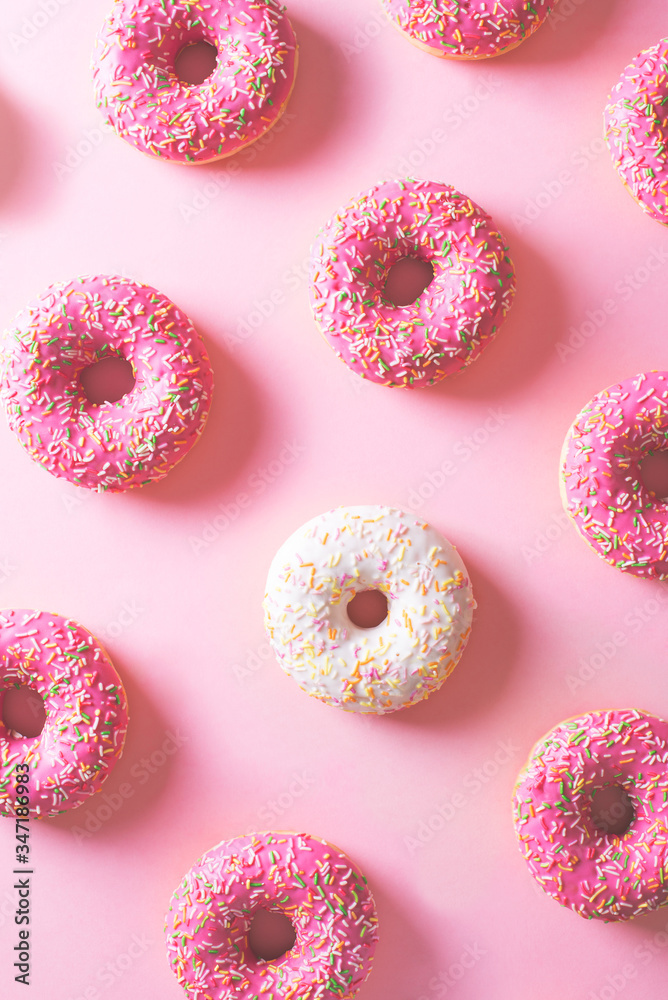 Flat lay with pink donuts or doughnuts pattern, vertical, on pink background Flat lay with pink donuts or doughnuts pattern, vertical, on pink background