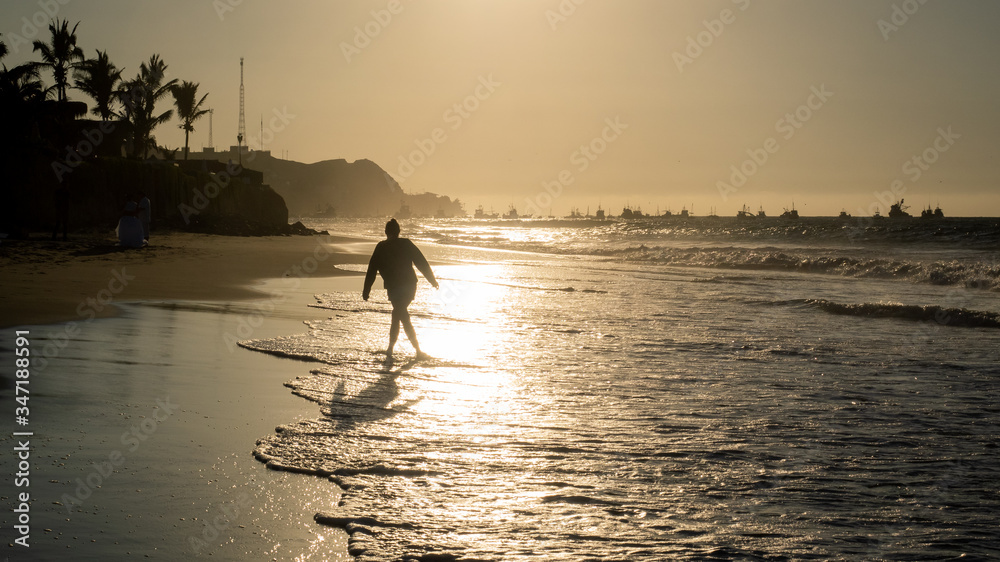 Girl walking along the beach in Mancora