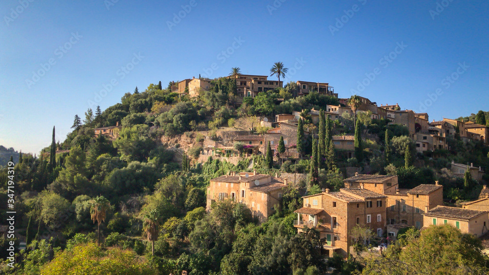 Scenic view of Deia, Majorca against blue sky.