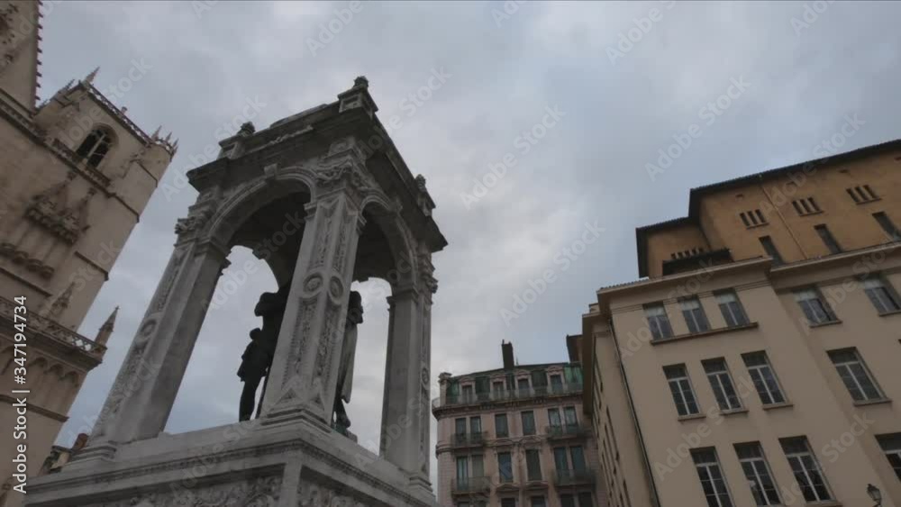 PAN SLOW MOTION - The fountain of Saint John the Baptist and the front elevation of the Lyon Cathedral (Cathedrale Saint-Jean-Baptiste de Lyon) in the background. PAN SLOW MOTION - The fountain of Saint John the Baptist and the front elevation of the Lyon Cathedral (Cathedrale Saint-Jean-Baptiste de Lyon) in the background.