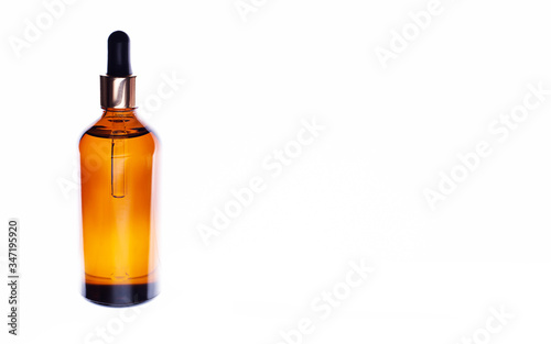 Organic natural oil in a brown bottle on a white background with empty space