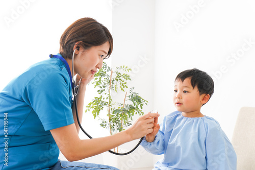 子どもを診察する若い看護師
