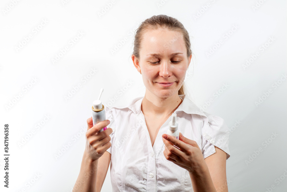 Young and attractive doctor with a throat spray isolated on white Young and attractive doctor with a throat spray isolated on white