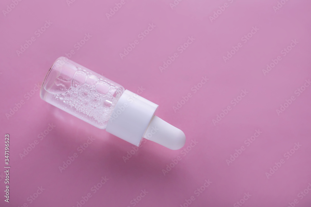 Flat lay with serum bottle with liquid on pink background Flat lay with serum bottle with liquid on pink background