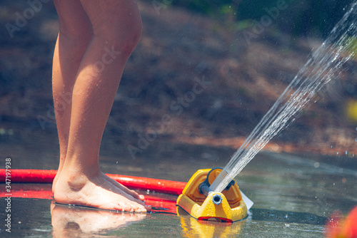 Low view kids feet in water sprinkler  summer fun  beat the heat  quarantine activity 