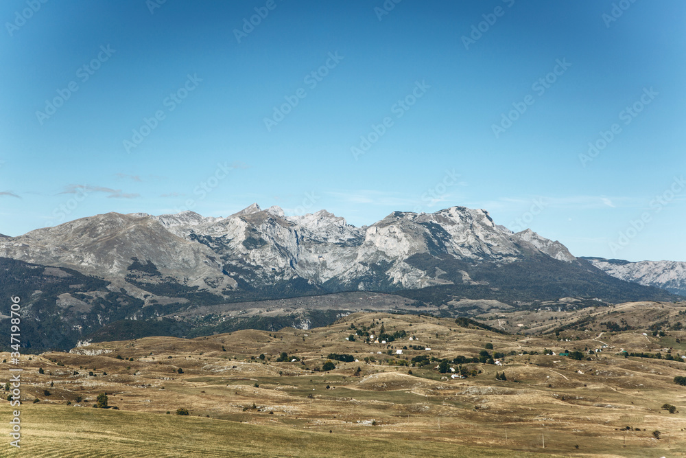 Beautiful panoramic view of the mountains and rural landscape against the blue sky in Montenegro.