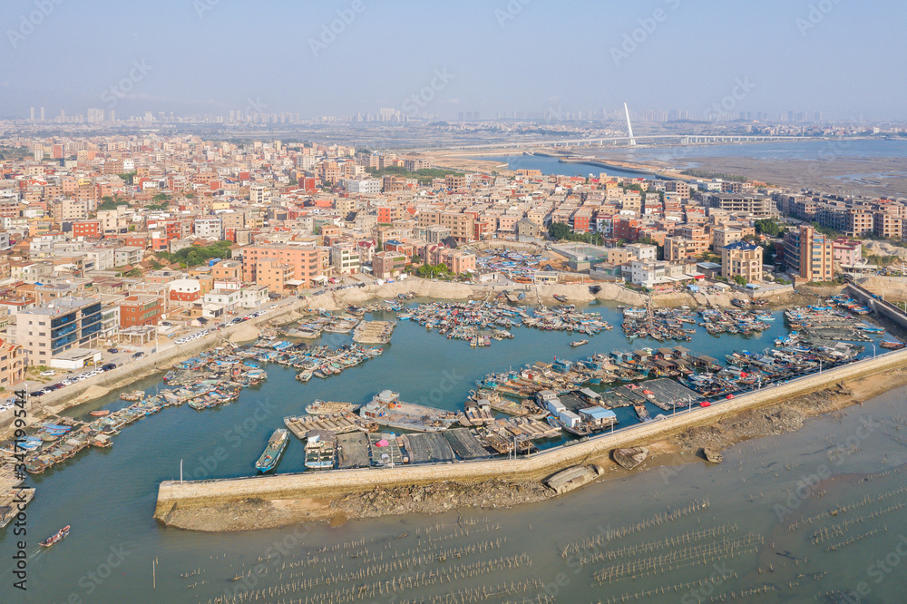 Aerial view of a Chinese traditional fishing village around Xiamen city, with residential buildings and fishing boats