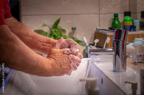 washing hands in the bathroom as protection against corona virus and covid-19 photo