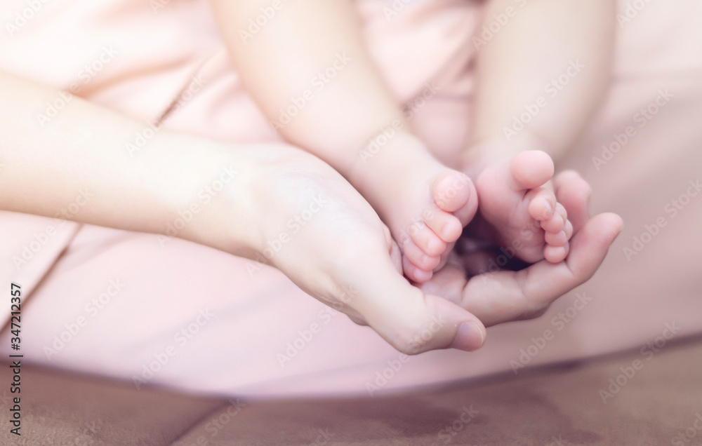 close up mother holding new born baby toddler feet in her palm, warm love and caring for child in motherhood and parenthood, mom looking after baby playing having bonding and touching cleaning feet close up mother holding new born baby toddler feet in her palm, warm love and caring for child in motherhood and parenthood, mom looking after baby playing having bonding and touching cleaning feet