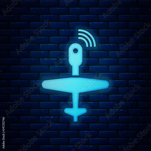 Glowing neon UAV Drone icon isolated on brick wall background. Military Unmanned aircraft spy.  Vector Illustration
