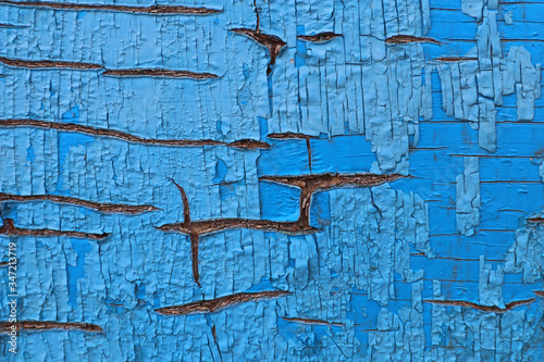 Old cracked blue paint on a wooden board. Texture.
