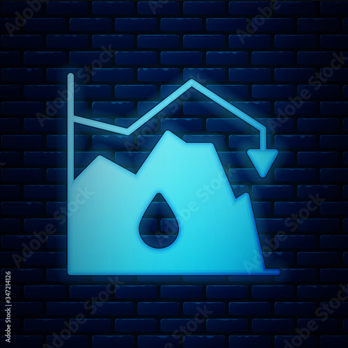 Glowing neon Drop in crude oil price icon isolated on brick wall background. Oil industry crisis concept.  Vector Illustration