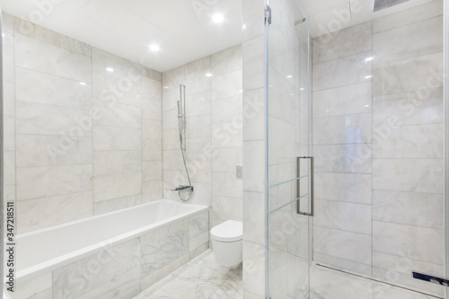 Simple bathroom interior with bathtub   shower  and marble walls