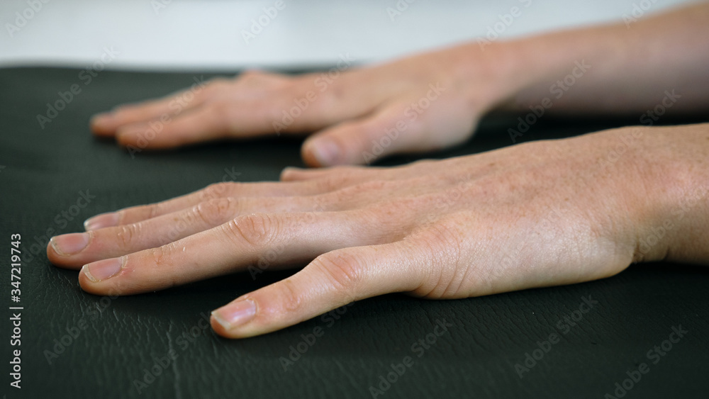 Fototapeta premium Close of hands on yoga mat female