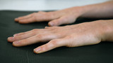 Close of hands on yoga mat female