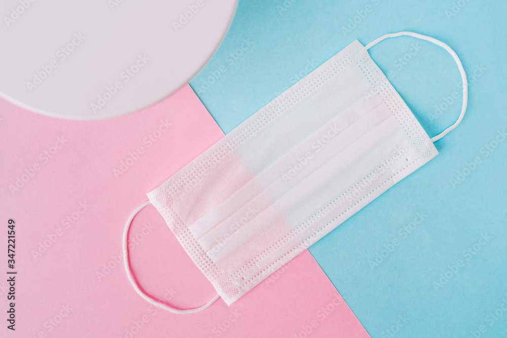 Medical mask on a pastel pink and blue geometry background. Prevent the coronavirus. Protection concept Medical mask on a pastel pink and blue geometry background. Prevent the coronavirus. Protection concept