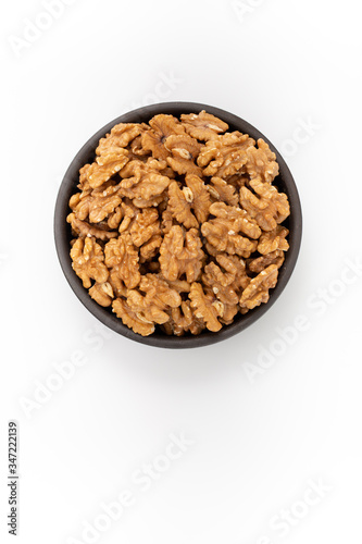 Cleaned Walnuts in round bowl on white background, top view