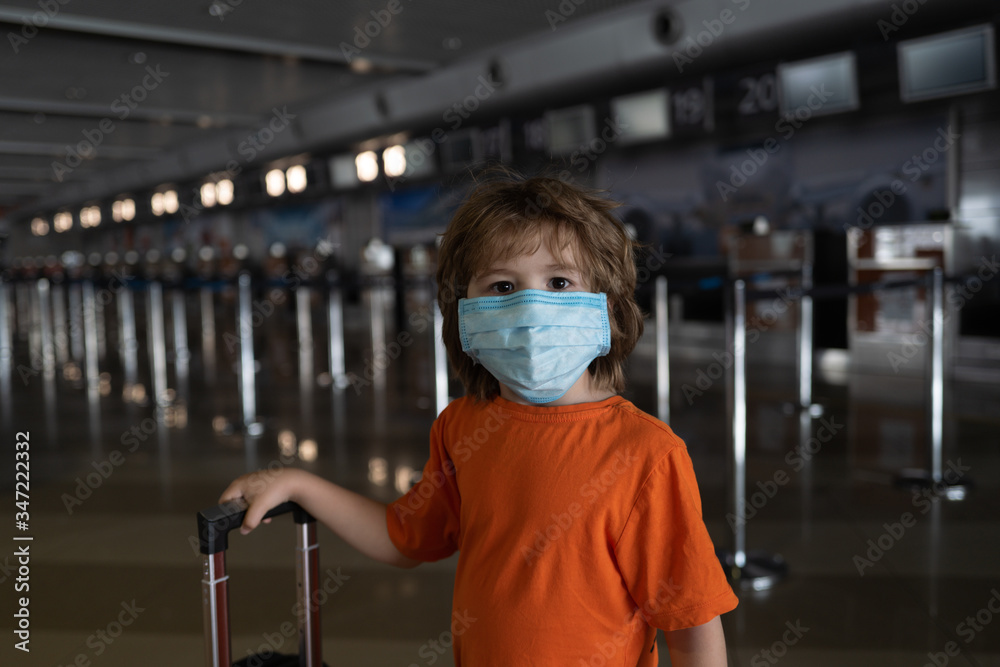 Stay at home quarantine coronavirus pandemic prevention. Sad child in protective medical mask. Prevention epidemic. A child with a suitcase at the airport. Stay at home quarantine coronavirus pandemic prevention. Sad child in protective medical mask. Prevention epidemic. A child with a suitcase at the airport.
