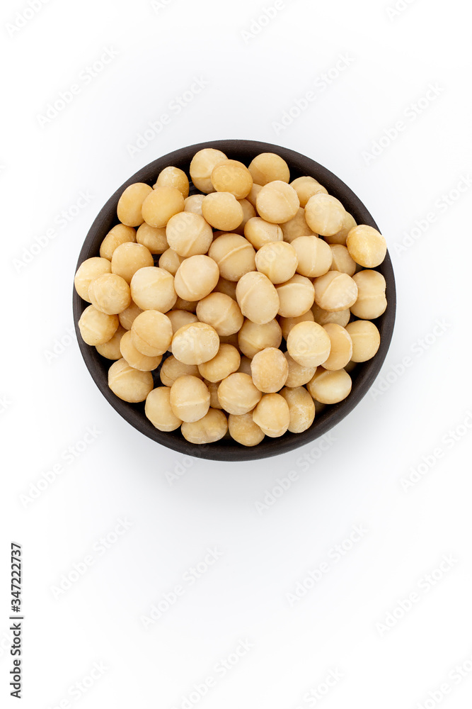 Cleaned Macadamia nuts in round bowl on white background, top view Cleaned Macadamia nuts in round bowl on white background, top view
