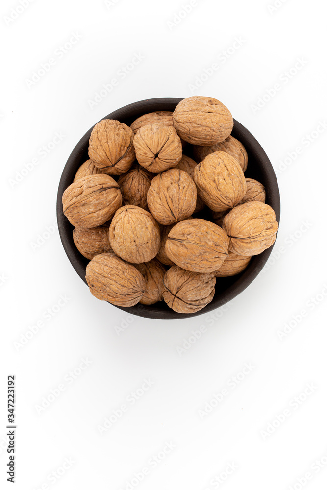 Walnuts in round bowl on white background, top view Walnuts in round bowl on white background, top view