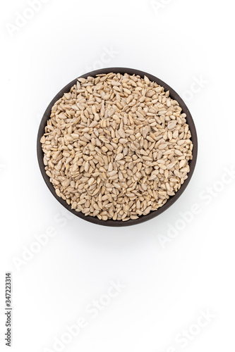 Sunflowers seeds in round bowl on white background, top view
