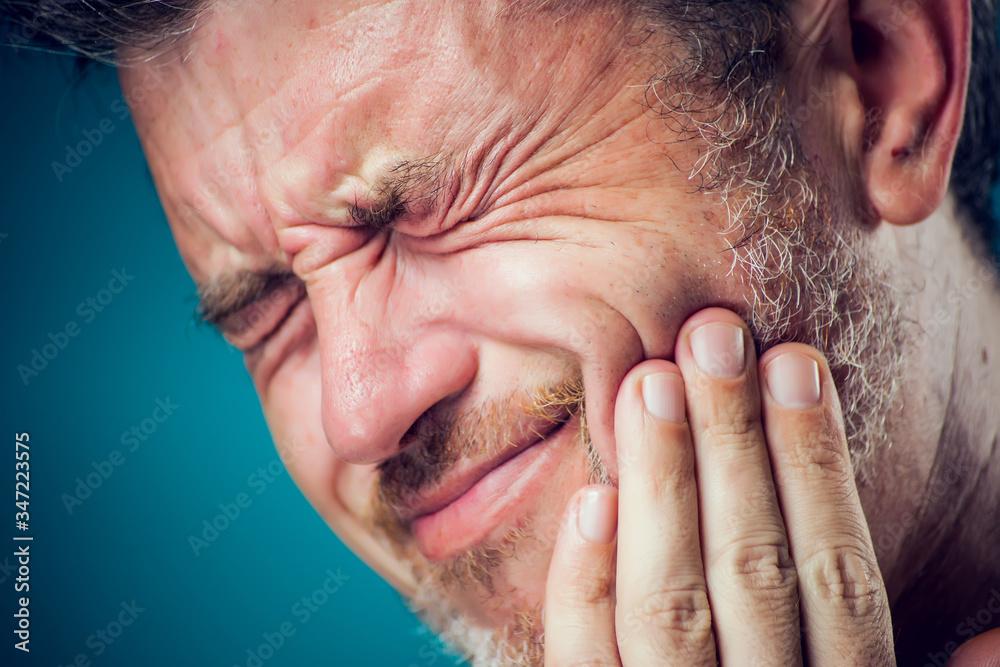 A man feeling toothache. Close up. People, healthcare and medicine concept. A man feeling toothache. Close up. People, healthcare and medicine concept.
