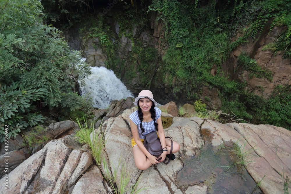 Women enjoying the view of the waterfall in Khlong Wang Chao Kamphaeng Phet National Park, Thailand