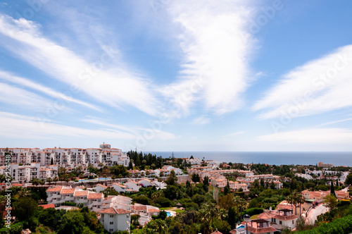 Panoramic view of the Spanish coastal city, the sea and with light feather clouds in the sky