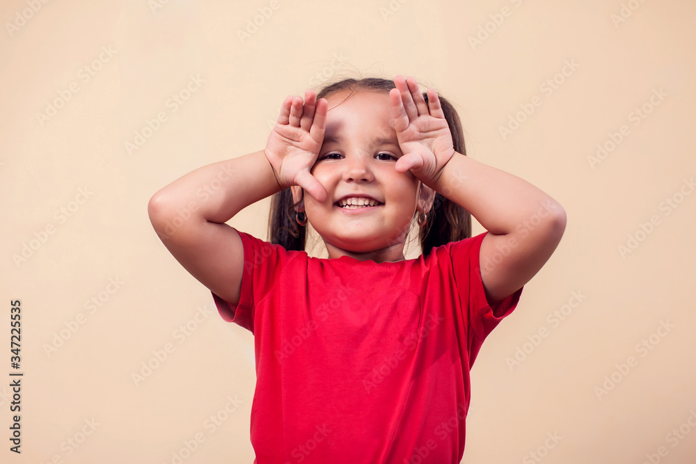 A portrait of kid girl funny frightening with hands at camera. Childhood and emotions concept A portrait of kid girl funny frightening with hands at camera. Childhood and emotions concept