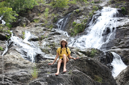 Woman sitting at Khlong Nam Lai waterfall in Klong Lan national park, Kamphaeng Phet, Thailand