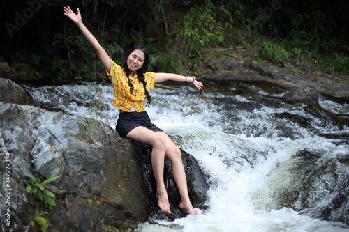 Woman sitting at Khlong Nam Lai waterfall in Klong Lan national park  Kamphaeng Phet  Thailand