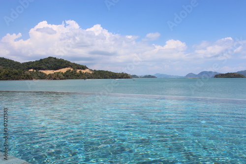 View of the sea and mountain islands through the infinity pool at a beach resort in Langkawi, Malaysia