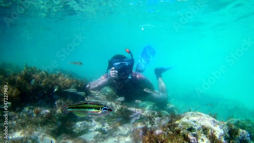 Photographer using camera in waterproof box to make photos and video underwater