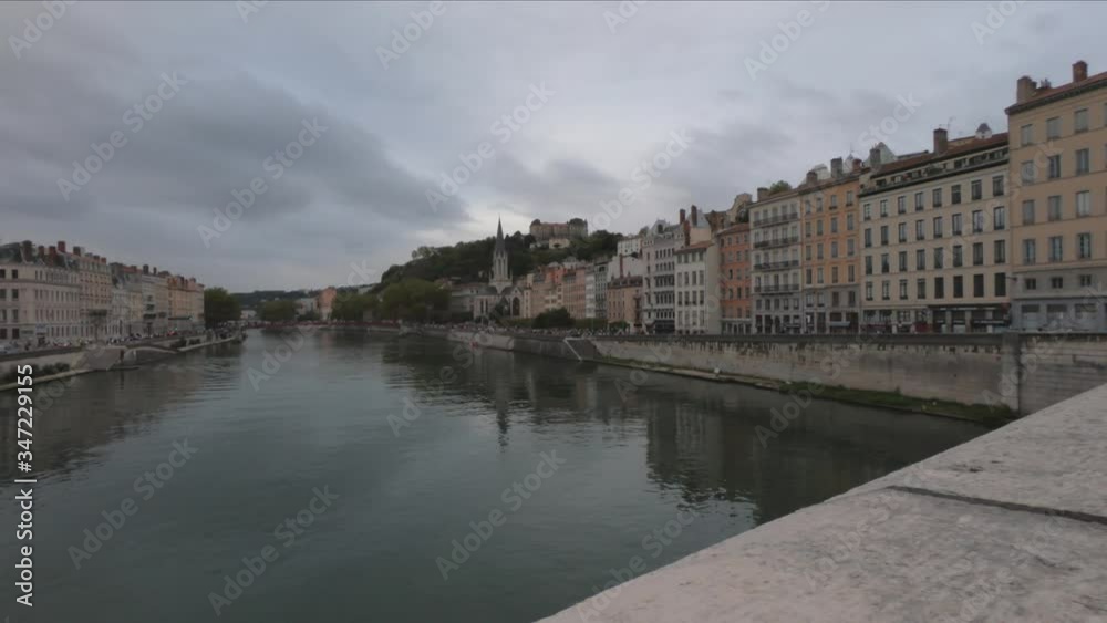 DOLLY SLOW Heading into Vieux Lyon over the Pont Bonaparte. Quai Tilsitt and Quai Fulchiron on the banks of the Saone river, Passerelle, Saint Georges church and Saint-Just College on Fourviere hill.