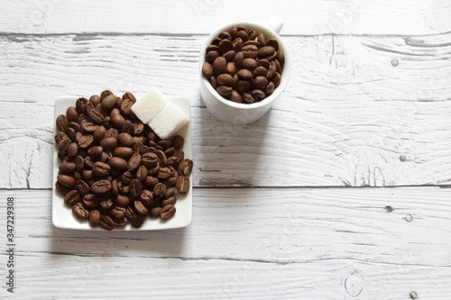 Coffee beans and sugar cubes for cooking breakfast. Copyspace for text. Top view. Flatlay on a wooden background.
