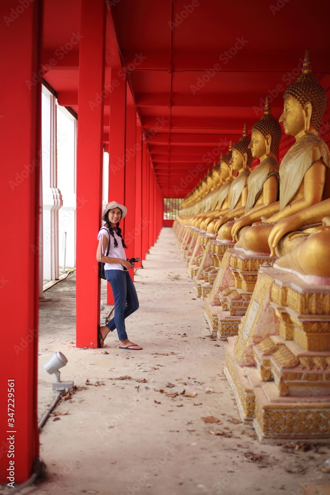Woman standing at the line of Buddha statue in Wat Tha Sung, Uthai Thani, Thailand.