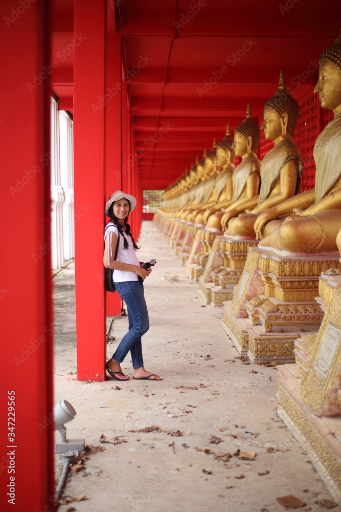 Woman standing at the line of Buddha statue in Wat Tha Sung, Uthai Thani, Thailand.