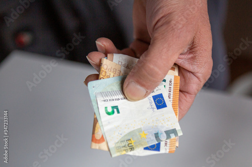 Euroscheine gefaltet in einer männlichen Hand