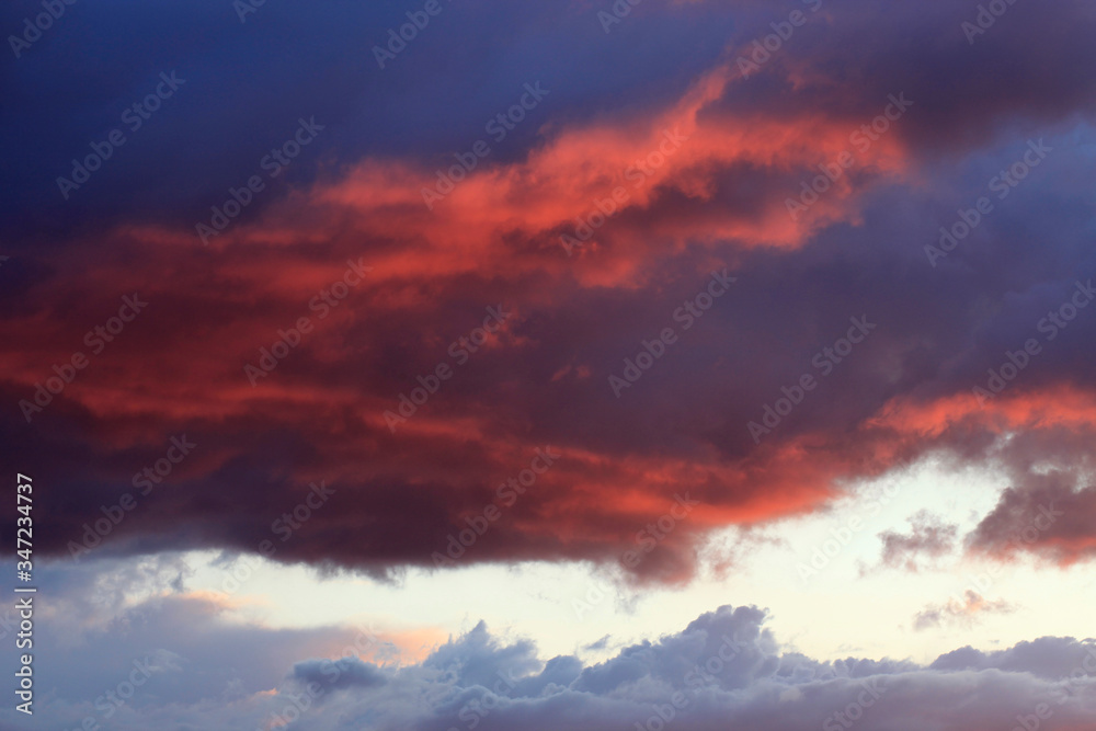 Beautiful heavenly landscape at sunset. Red and blue clouds in the evening sky