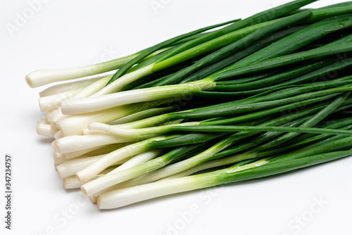 bunch of green fresh onions on a white background