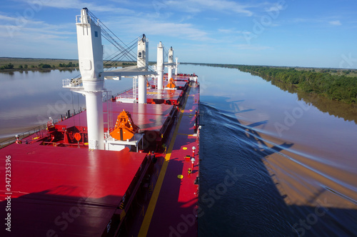 Vessel proceeding up the Parana River. Type of ship: Bulk carrier with cranes. Rio Parana, Argentina. photo
