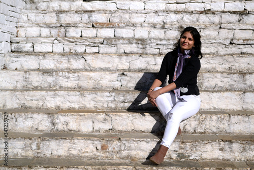 A young beautiful Indian woman sitting on the stairs