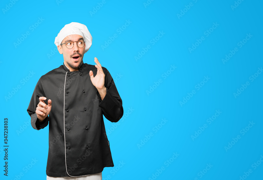 Friendly young chef doing a gesture of admiration Friendly young chef doing a gesture of admiration