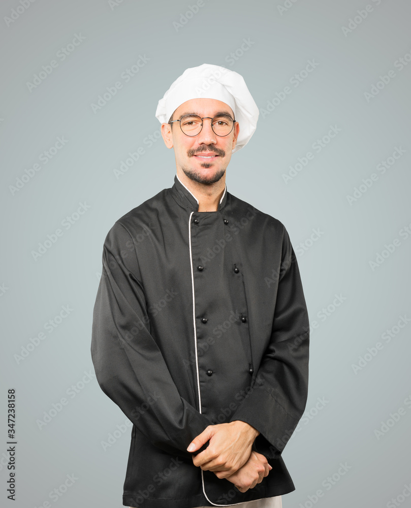 Happy young chef posing against background Happy young chef posing against background