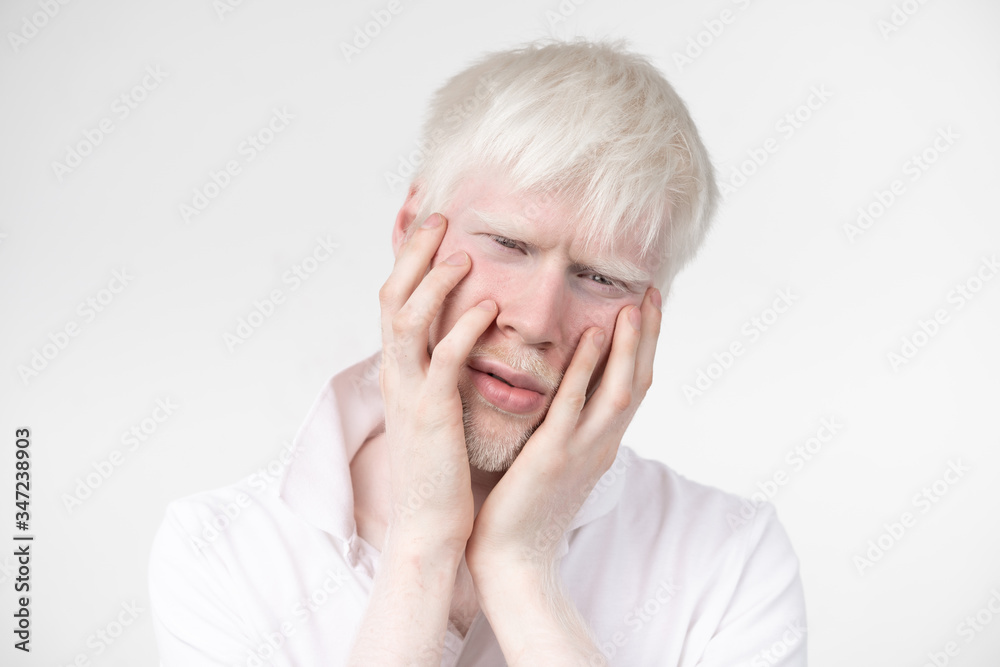 portrait of an albino man in studio dressed t-shirt isolated on a white background. abnormal deviations. unusual appearance portrait of an albino man in studio dressed t-shirt isolated on a white background. abnormal deviations. unusual appearance