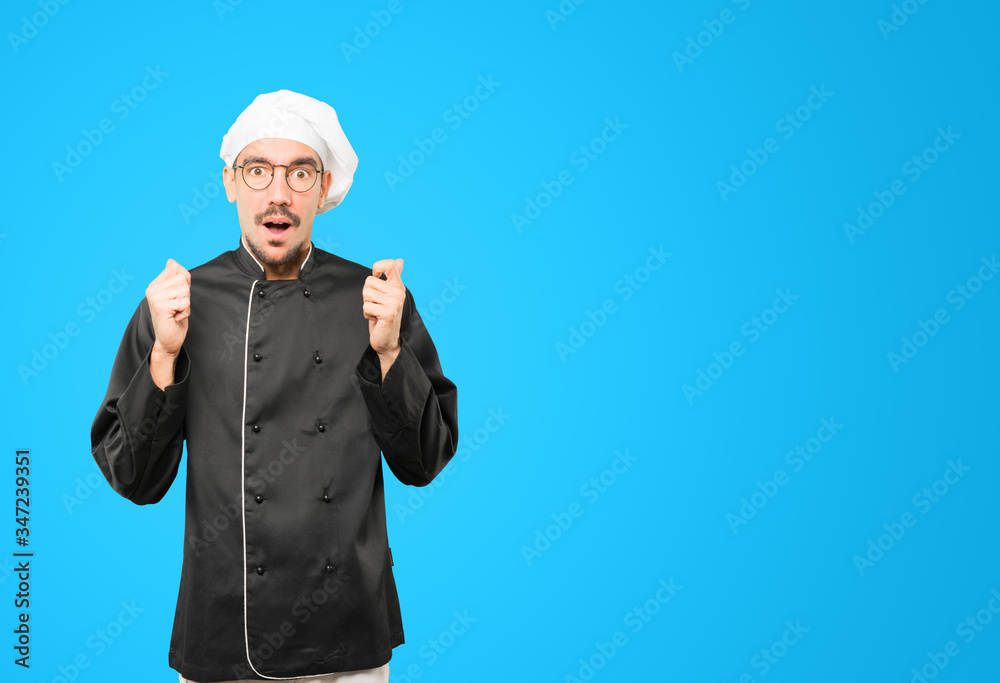 Astonished young chef with a gesture of shock Astonished young chef with a gesture of shock